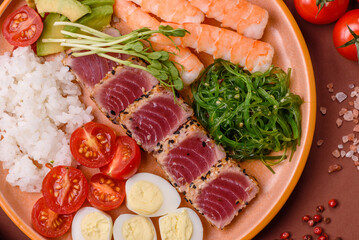 Seafood bowl, tuna tataki fillet slices with rice, oranges, tomatoes and sauce. Tuna bowl