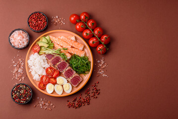 Seafood bowl, tuna tataki fillet slices with rice, oranges, tomatoes and sauce. Tuna bowl