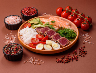 Seafood bowl, tuna tataki fillet slices with rice, oranges, tomatoes and sauce. Tuna bowl