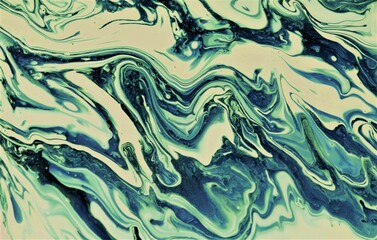 Blue, green and white abstract background made of acrylic paint. Acrylic paint mixes and creates an interesting pattern.
