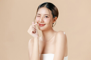 Young Asian woman portrait natural make up cosmetic on face radiant eyes lip gloss happy touch her...