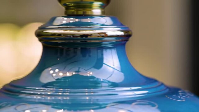 Close-up of a glossy, teal lamp base with a metallic accent