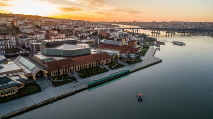 Aerial drone view of Halic Congress Center in Istanbul, modern architecture surrounded by cityscape and waterfront.