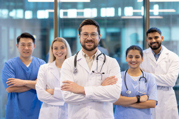Fototapeta premium A team of diverse healthcare professionals confidently smiling in a modern hospital setting. Showcasing teamwork and dedication in providing quality medical care and fostering trust with patients.