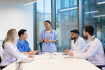 Medical professionals engaging in a collaborative discussion around a table in a modern office environment, showcasing communication, teamwork, and professional exchange.