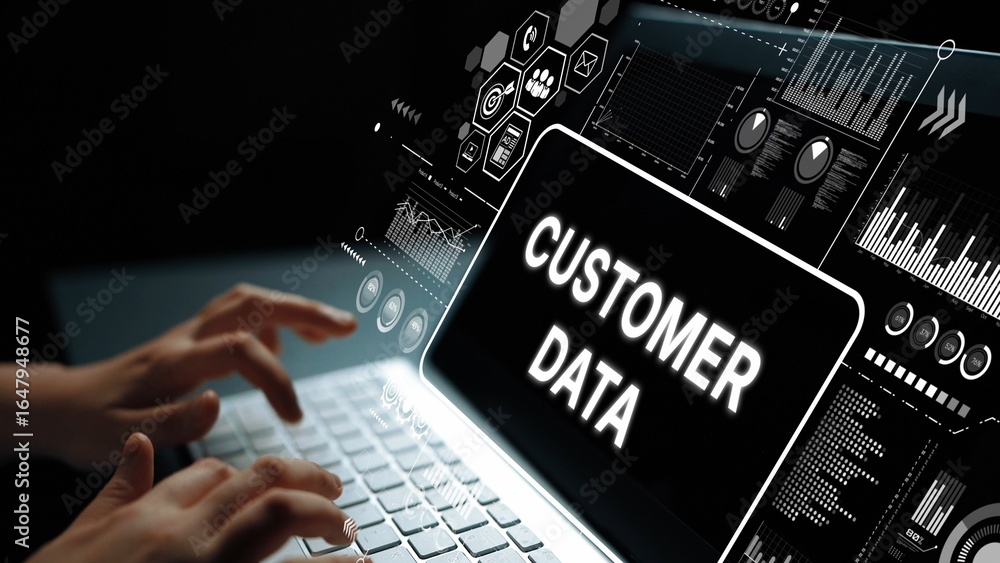 Poster hands typing on a laptop keyboard with digital screen displaying customer data and analytics in a da