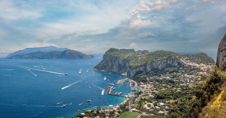 Obraz premium Sweeping views from the heights of Anacapri with the marina and village of Capri in the foreground and Sorrento in continental Italy in the background, Capri Island, Italy