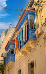 Clothes drying on the historic balconies and windows of the old town of Birgu, across the grand harbor from Valletta, Malta