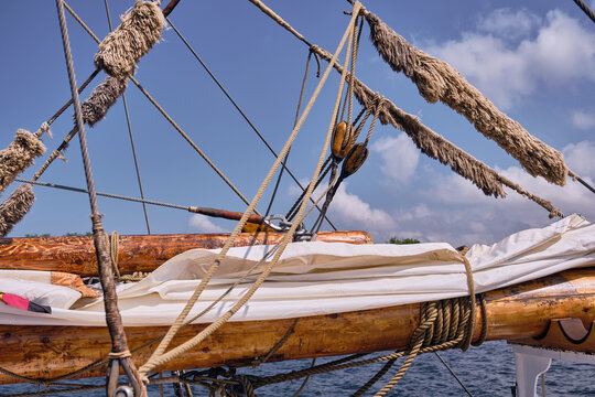 Gaff rig boom with furled mainsail and guiding lines on sailing ship Nobile