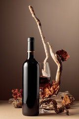 Bottle and glass of red wine with a composition of old wood.