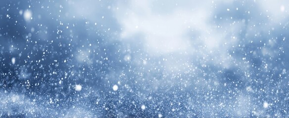 Obraz premium The Snowfall Over a Soft Blue Winter Background with Gentle Bokeh Light