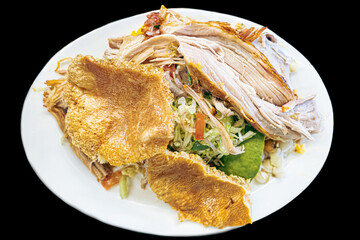 Ecuadorian hornado, a traditional Ecuadorian dish, oven-cooked until achieving juicy meat and...