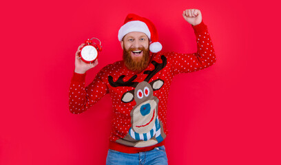 merry christmas. glad man with clock at christmas. santa man in christmas holiday isolated on red