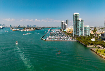 Luxury yacht docked at Miami marina. Aerial view of coastline in Miami. Sailboat cruising along the...