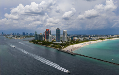 Luxury yacht cruising near Miami skyline. Aerial view of boats on turquoise waters in Miami. Yacht...