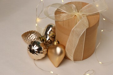 A festive wooden gift box with golden Christmas toys and warm garlands is the perfect photo for...
