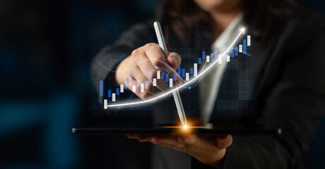 A professional using a digital tablet to illustrate financial graphs and charts, showcasing upward...