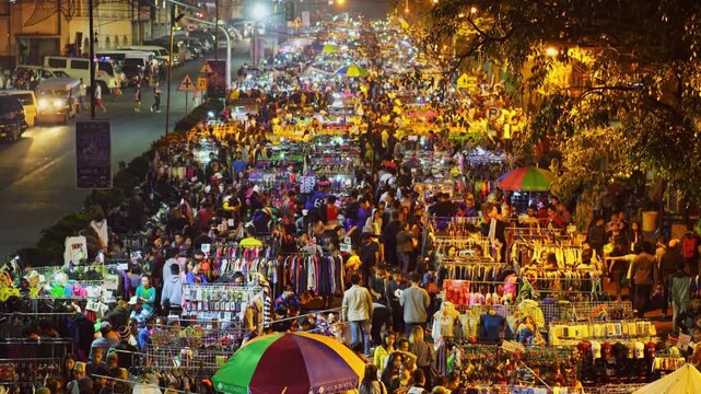A vibrant night market in india with a large crowd of people shopping