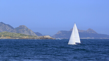 Sailboat sailing in Baiona, Cies Islands in the background