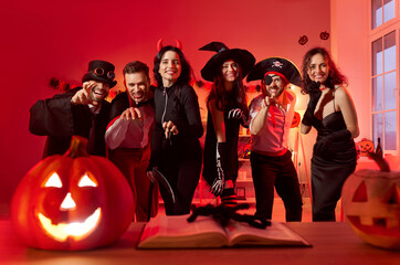 Gathering party for Halloween celebration, friends posing in scary costumes of vampire, witch,...