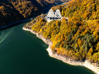 Scenic autumn road winding through vibrant fall foliage and mountains near a lake