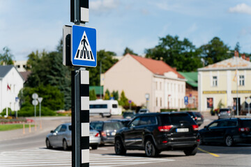 Pedestrian crossing sign at busy city intersection with cars in traffic, road safety...