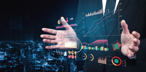 A businessman showcases interactive data analysis with advanced digital charts and graphs, set against a modern urban city skyline at night. Impute