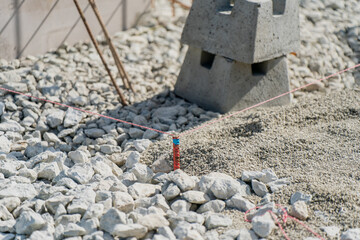Construction site alignment with string line and concrete blocks for foundation preparation. Construction wire system for precise groundworks calculation and markings