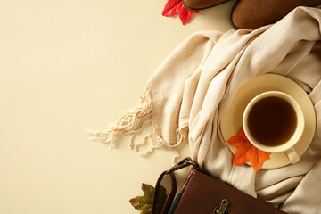 Warm autumn flat lay with cup of tea, scarf, shoes, handbag, and fall leaves on beige background....