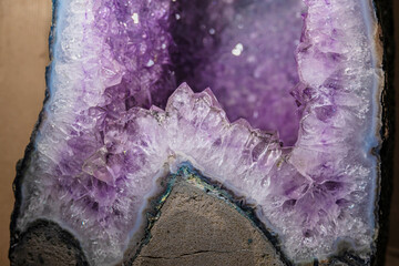 Stunning amethyst geode cross-section displaying vibrant purple crystals and natural agate banding....