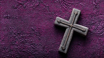 Stone cross resting on dark purple textured background offering concepts of Christianity and faith