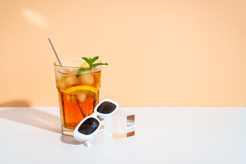 Summer iced cocktail drink with sunglasses and sunny shadows.