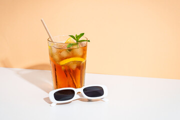 Summer iced cocktail drink with sunglasses and sunny shadows.