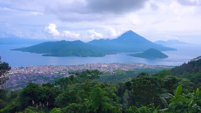 Exotic islands in the tropical Spice Islands (Moluccas). Indonesia. Indian Ocean. Cruise sea voyage place, seaport town. Rain mountain forest in the foreground