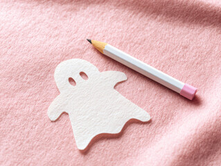 top view, tWhite ghost stencil on pink fabric with pencil, ready for tracing—ideal for DIY Halloween decor tutorials, craft blogs, or seasonal project guides.