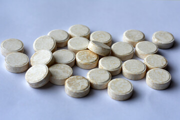 Round pills on white background. Yellow round vitamin tablets. Set of pills. Health and medicine concept.