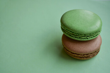 Cake french macaroon  on green background. Sweet and colorful dessert. Two colorful macaroons . Green and brown macaroons.