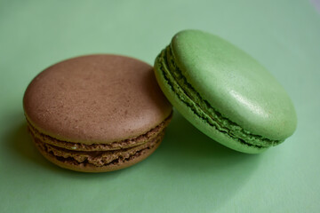 Cake french macaroon  on green background. Sweet and colorful dessert. Two colorful macaroons . Green and brown macaroons.