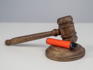 Judge's gavel and e-cigarette. Smoking ban. Tobacco heating systems. 