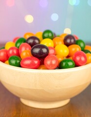 Colorful candies in a wooden bowl against a blurred background of lights