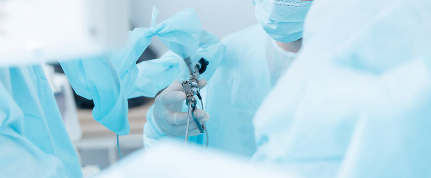 Laparoscopic surgery for prostate adenoma with medical team in hospital, banner blue light