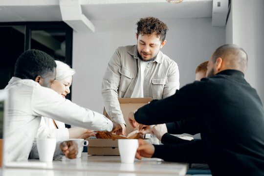 Diverse Team Sharing Pizza During Office Break for Team Building and Collaboration - Powered by Adobe