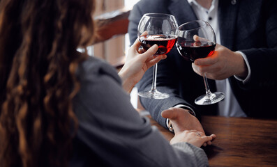 Romantic dinner date with young couple toasting red wine in restaurant, banner