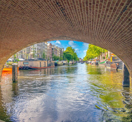 Naviganting under a low bridge in Amterdam's historic canal system, Holland, the Netherlands