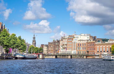 Navigating the inner Amstel river (Binnenamstel) in the  city center of Amsterdam with the historic Muntttoren uin the background, Holland, the Netherlands