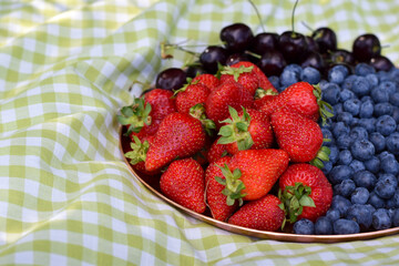 platter of strawberries, blueberries, and cherries