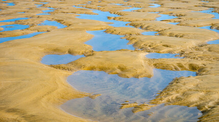 Mesmerwing sand dune and low tide sea water pools in the beaches of Soulac sur mer, Côte d'argent, Nouvelle Aquitaine, France