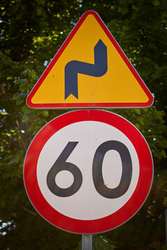 Road sign warning of winding road ahead and 60kmh speed limit