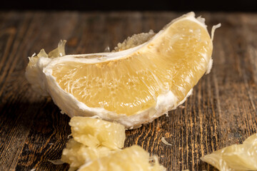 peeled pieces of delicious and sweet citrus fruit while preparing it for eating, close up
