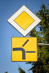 Priority road with side road merging from the left traffic sign